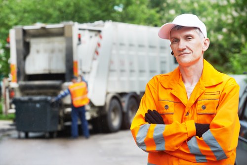 Junk removal team loading household waste into a collection vehicle
